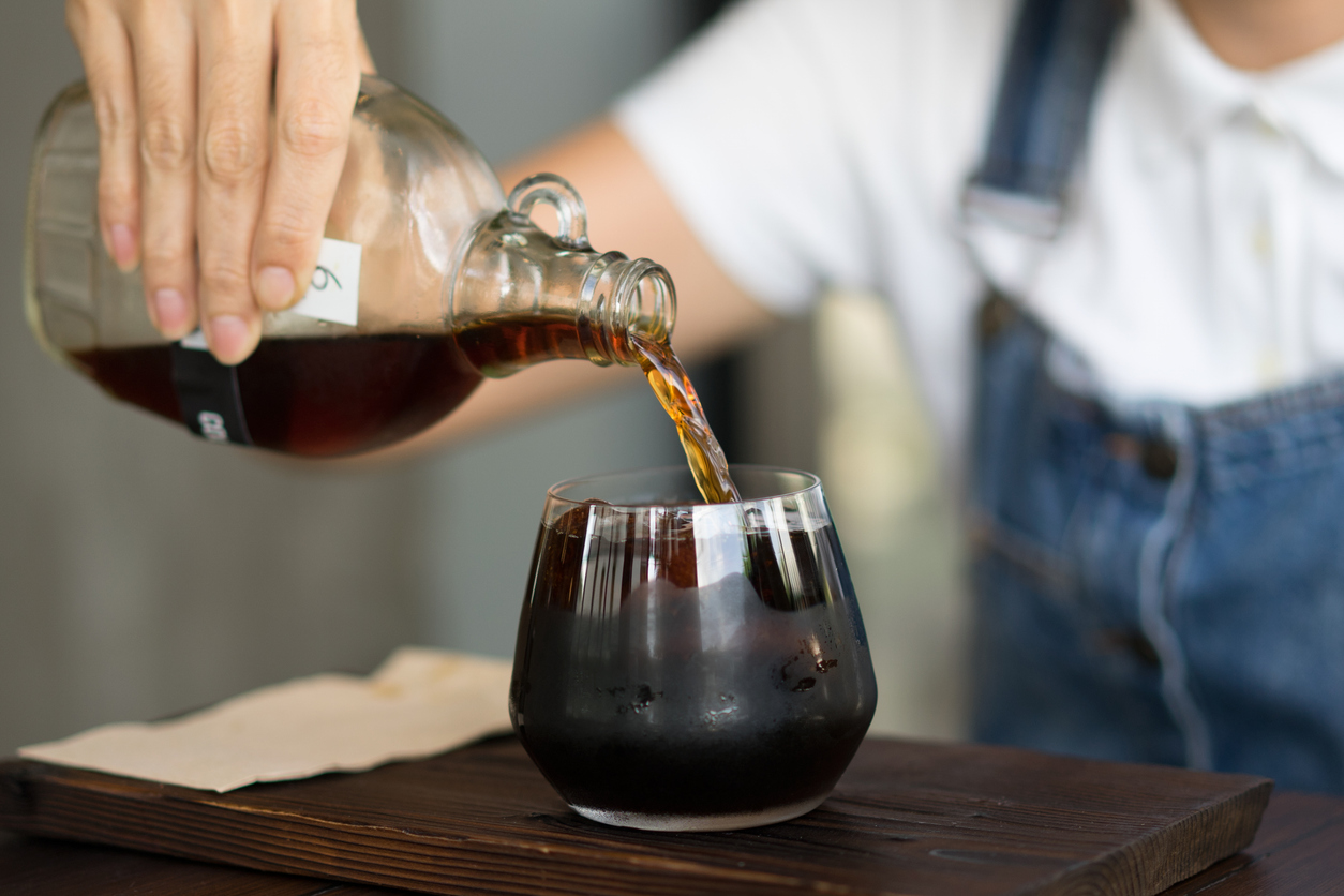 a woman pouring cold brewed coffee