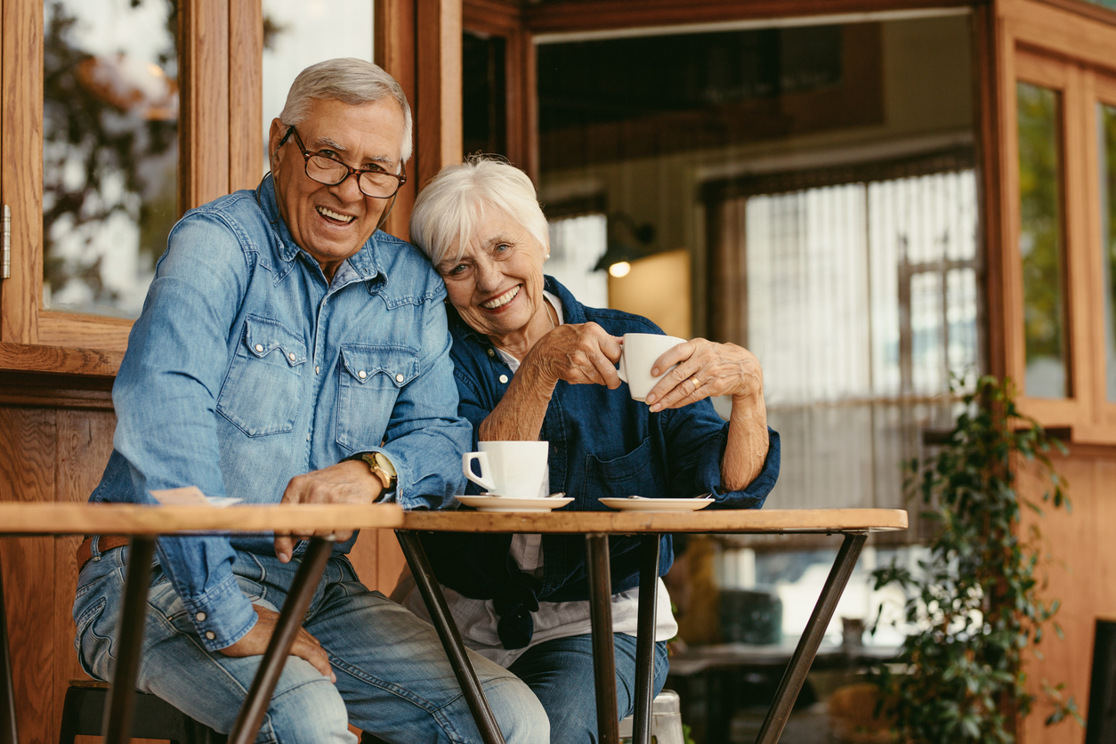 senior couple enjoying coffee outside a coffee shop