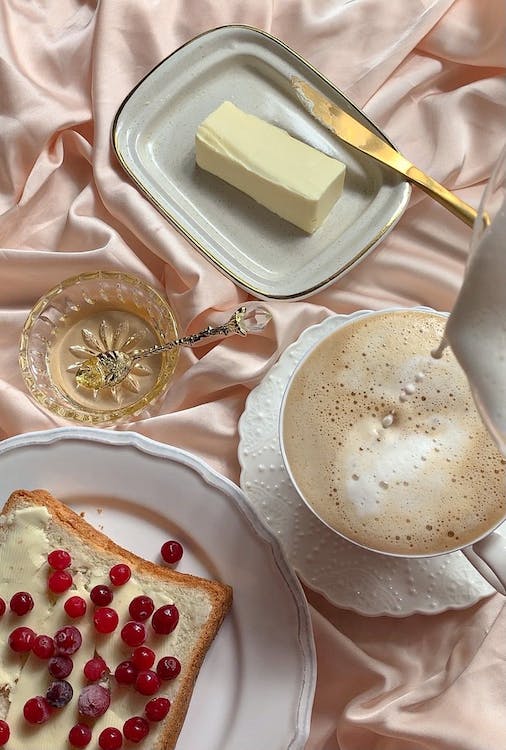 creamy coffee being poured to cup with butter in the side