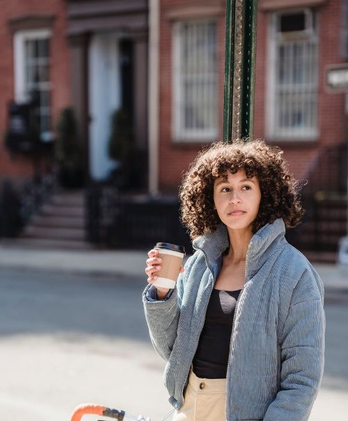Person having a cup of coffee in the morning on a bicycle