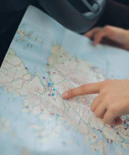 Person pointing a finger at the world map