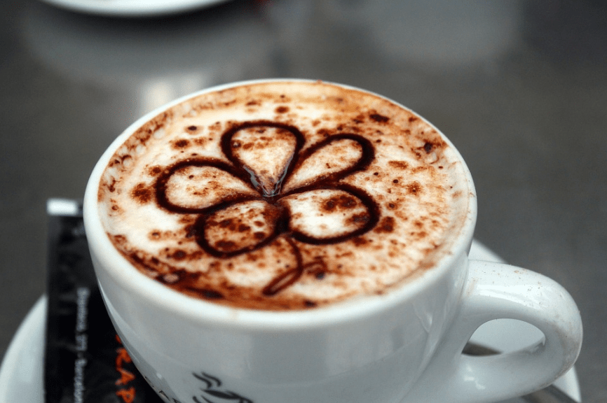 a cup of coffee cappuccino with a flower design