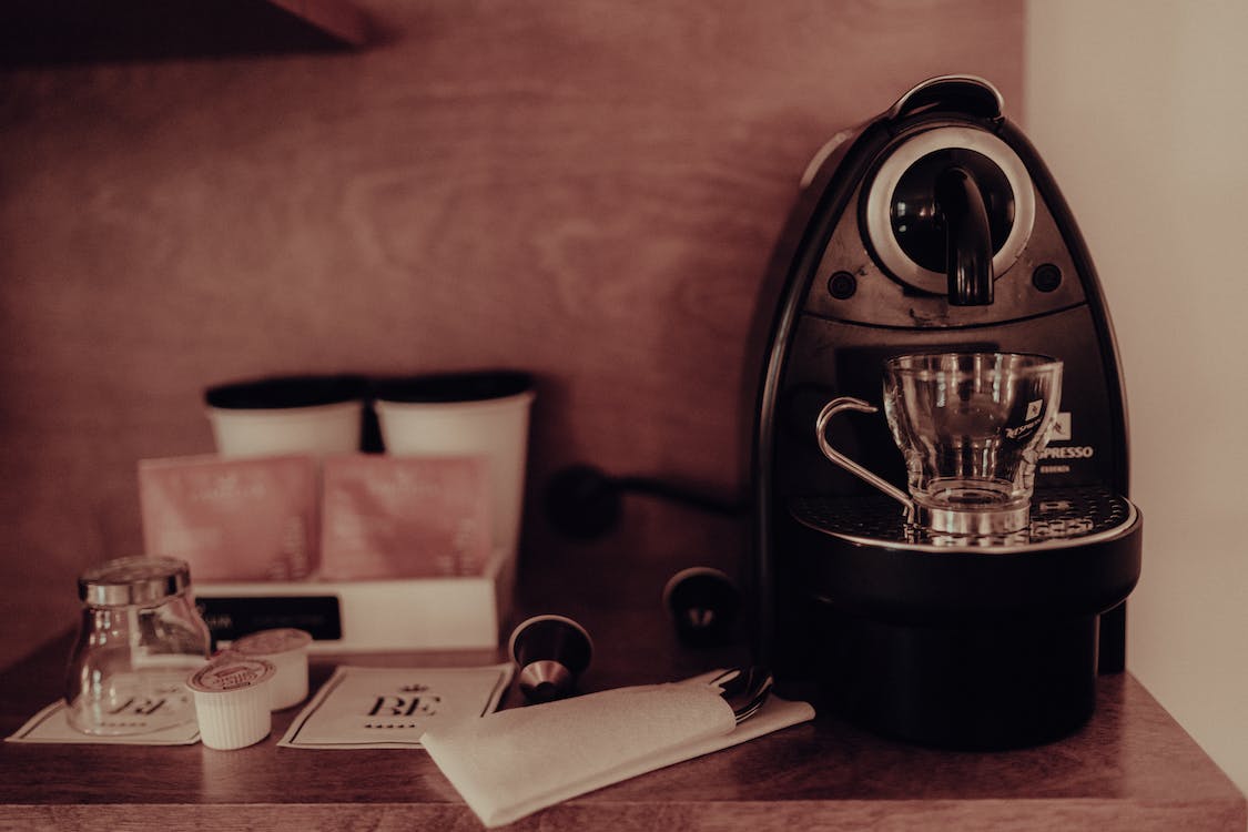 Close up of a coffee maker with spout and other accessories on the table