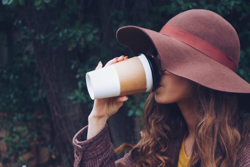 woman drinking a large cup of coffee