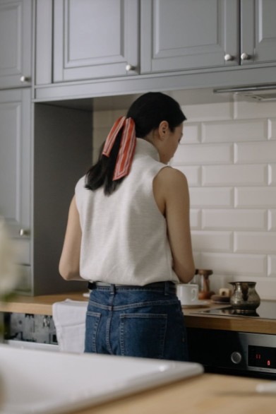 A person standing over a cooking range in a kitchen