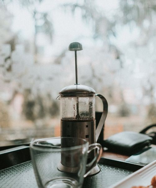 French press with a cup on a tray