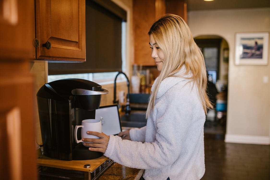 A woman making coffee with a coffee machine