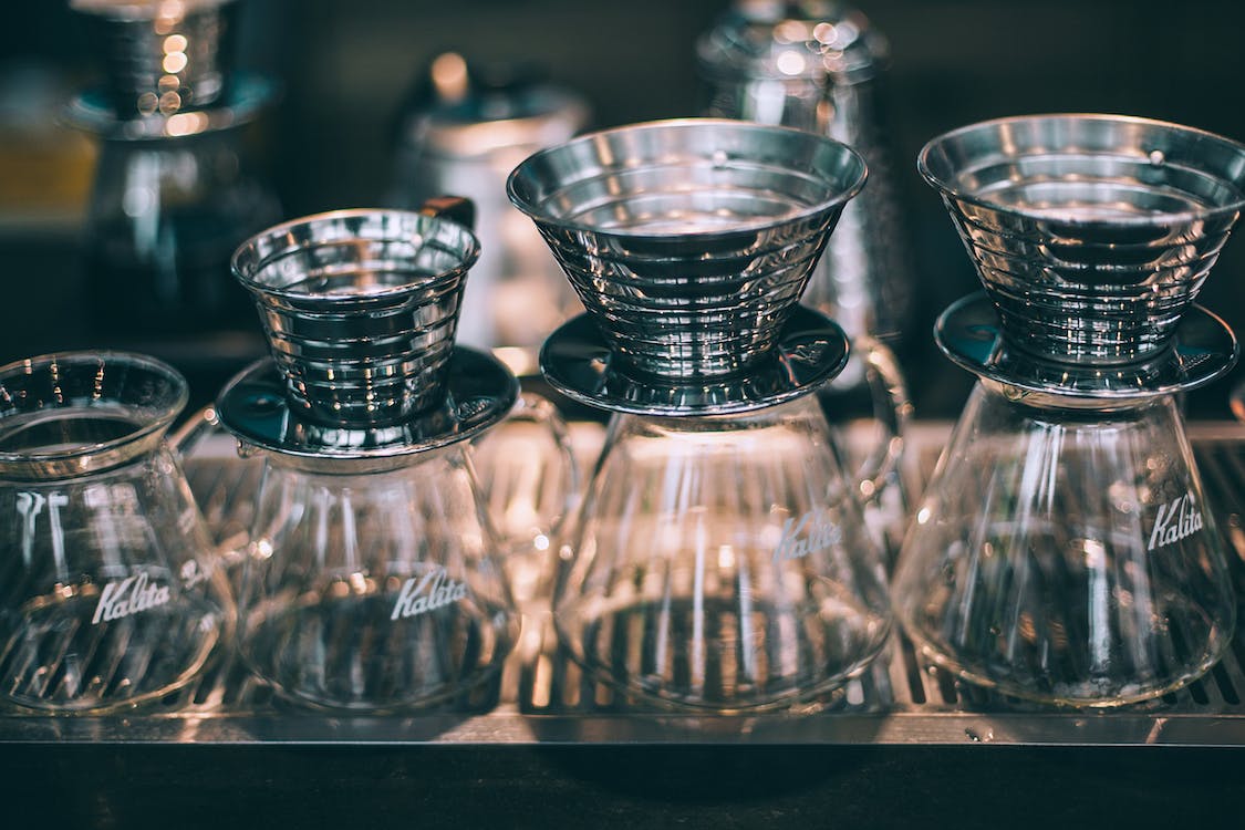 Close-up of metal coffee filters with glass server at the botttom