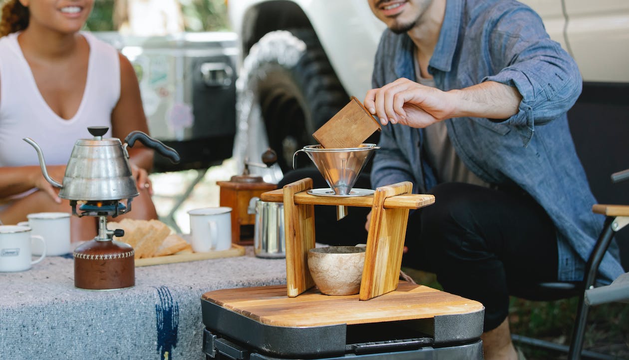 Man making pour-over coffee with pour-over stand holding the dripper