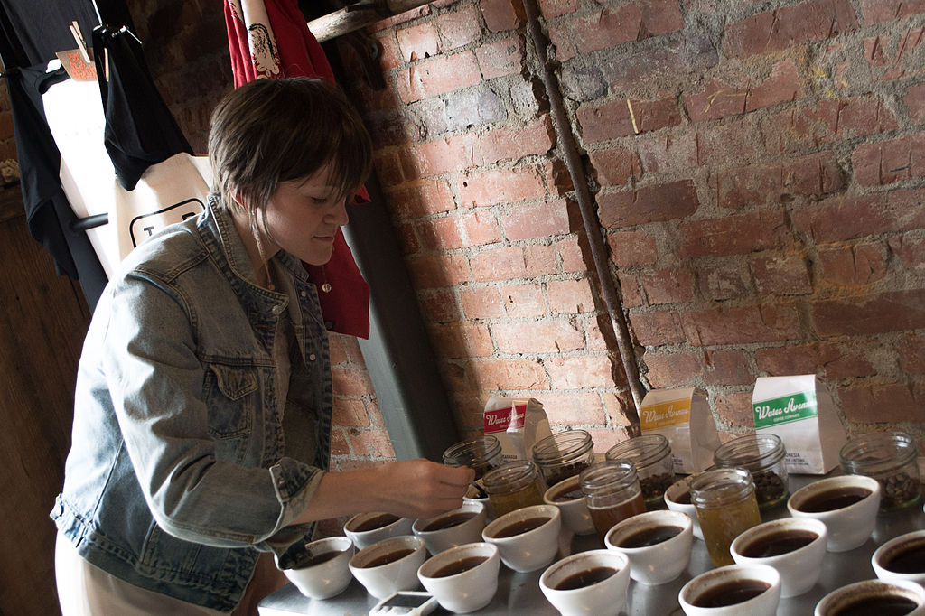 Woman looking at coffee cup samples on table during the cupping process