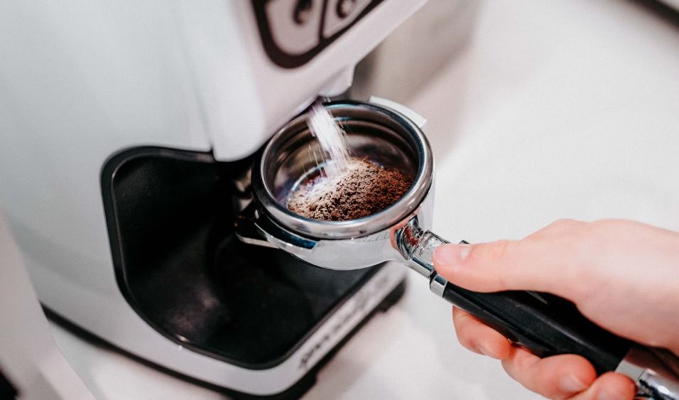woman preparing coffee on a coffee machine